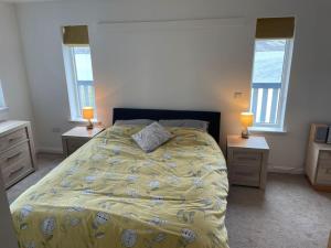 um quarto com uma cama com duas mesas de cabeceira e duas janelas em Wasterview, Central Mainland, Ideal base em Lerwick