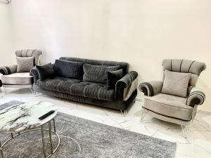 a living room with a leather couch and two chairs at Luxury home in Beylikduzu in Beylikduzu