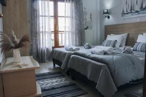 a bedroom with two beds and a large window at Villa Evgenia(Leonidas) in Ierissos