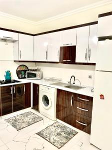 a kitchen with white cabinets and a washer and dryer at Luxury home in Beylikduzu in Beylikduzu