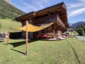 a log cabin with a yellow tent in front of it at Chalet Morzine, 7 pièces, 8 personnes - FR-1-627-23 in Morzine