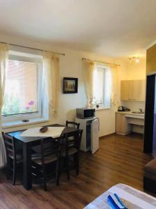 ein Wohnzimmer mit einem Tisch und Stühlen sowie eine Küche in der Unterkunft Vila Mária Rapovce in Rapovce