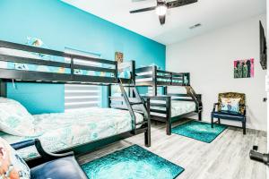 a bedroom with bunk beds and a blue wall at Sea Cove in Galveston