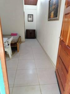 a hallway with a white tile floor and a room with a table at Sol de la India - Pueblo Nuevo in Pueblo Nuevo