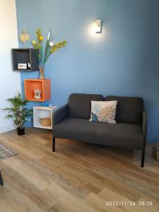studio vue imprenable sur marseille في مارسيليا: أريكة في غرفة معيشة مع جدار أزرق