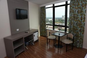 Uma TV ou centro de entretenimento em Hotel Golden Park Internacional Foz & Convenções By Nacional Inn