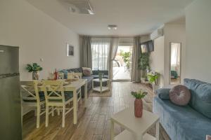 - un salon avec un canapé bleu et une table dans l'établissement Happy Apartments, à Balatonlelle