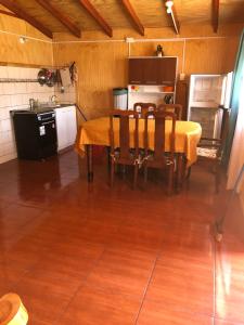 eine Küche mit einem Tisch und Stühlen im Zimmer in der Unterkunft Cabañas melinka in Licán Ray