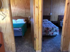 ein kleines Zimmer mit 2 Betten und ein Zimmer mit 2 Betten in der Unterkunft Cabañas melinka in Licán Ray