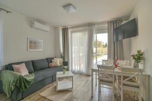 sala de estar con sofá azul y mesa en Happy Apartments en Balatonlelle