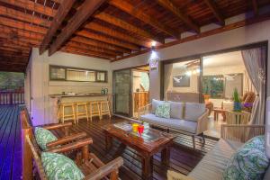 a screened in porch with a couch and a table at Call of the Fish Eagle Self-catering Holiday Home with solar in Marloth Park