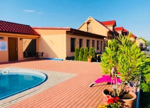 a brick patio with a swimming pool and a house at Vila Mária Rapovce in Rapovce