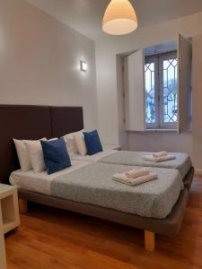 a bedroom with a bed with blue pillows and a window at Clérigos Ville Porto Rooms in Porto