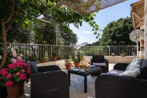 a patio with chairs and a table and flowers at Studio and Room Lena in Dubrovnik