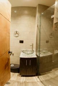 a bathroom with two sinks and a glass shower at Hostal Machu Picchu Medellín in Medellín