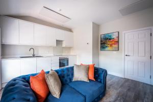 a blue couch in a kitchen with white cabinets at Dalton Sq Apartment 2 in Lancaster