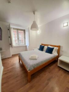1 dormitorio con 1 cama grande con almohadas azules en Clérigos Ville Porto Rooms, en Oporto