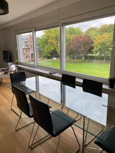 een glazen tafel en stoelen in een kamer met een raam bij Beautiful 3 bedroom Apartment in Antwerpen