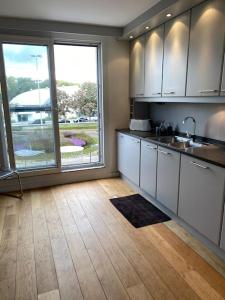 een keuken met witte kasten en een groot raam bij Beautiful 3 bedroom Apartment in Antwerpen