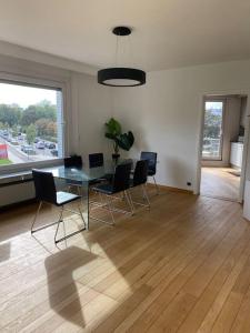 ein Wohnzimmer mit einem Glastisch und Stühlen in der Unterkunft Beautiful 3 bedroom Apartment in Antwerpen