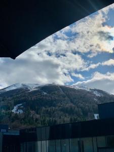 uma vista para uma montanha coberta de neve a partir de um edifício em Inverno Apartments Bjelašnica em Bjelašnica