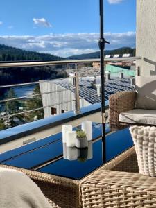 a balcony with a chair and a table with a view at Inverno Apartments Bjelašnica in Bjelašnica