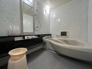 a bathroom with a tub and a toilet and a sink at 旭川ホテルカラーズ-大人専用 in Asahikawa