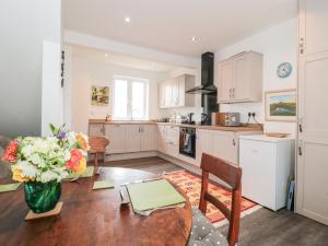 a kitchen with a table and a vase of flowers at Celia's View in Langport