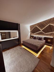 um quarto com uma cama grande e um espelho em Inverno Apartments Bjelašnica em Bjelašnica