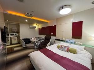 a bedroom with a bed and a living room at 旭川ホテルカラーズ-大人専用 in Asahikawa