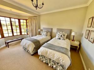 a bedroom with two beds and two windows at Bourne View in Nottingham Road