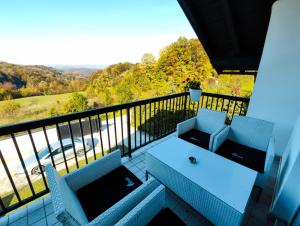 a balcony with a table and chairs and a view at Lexor Holiday Home in Tuzla