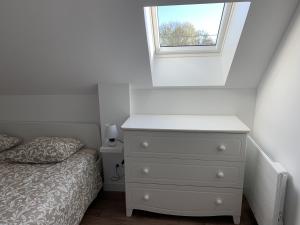 a bedroom with a white dresser and a window at Le Ch'ti Dodo in Guarbecque