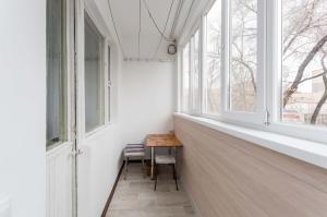 een kamer met een tafel en twee ramen bij Апартаменты на Сатпаева in Alma-Ata