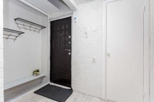 een zwarte deur in een witte kamer met een zwarte mat bij Апартаменты на Сатпаева in Alma-Ata