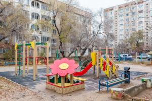 een speeltuin met kleurrijke apparatuur in een park bij Апартаменты на Сатпаева in Alma-Ata