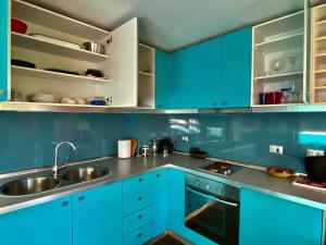 uma cozinha com armários azuis e um lavatório em MatiloftYungay em Valparaíso