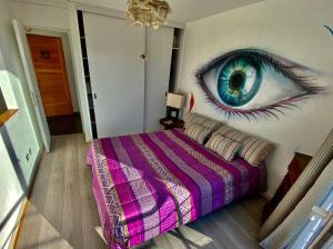 a bedroom with a peacock eye painted on the wall at MatiloftYungay in Valparaíso