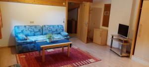 ein Wohnzimmer mit einem blauen Sofa und einem Tisch in der Unterkunft Haus Greiner in Nauders
