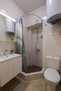 a bathroom with a toilet and a shower and a sink at The Red Point in Varna City