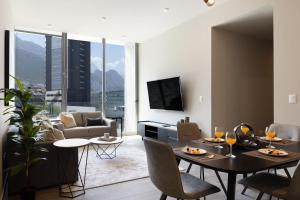 un soggiorno con tavolo, sedie e divano di Cerca de consulado EUA, nuevo, lujoso en Jardín Secreto 503 a Monterrey