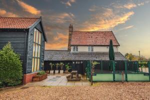 una casa con una valla delante de un patio en The Auberge en Yaxley