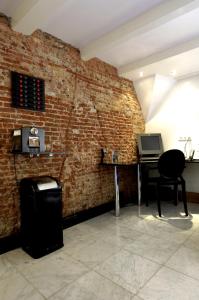a room with a brick wall with a desk and a laptop at Amsterdam Boutique Apartments in Amsterdam