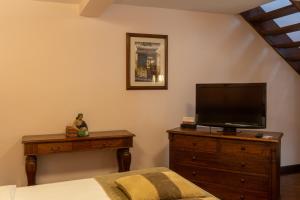 a bedroom with a tv on a dresser and a bed at Hotel Patio Andaluz in Quito
