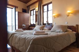 a bedroom with a large bed with towels on it at Kentavros Hotel in Agios Lavrentios