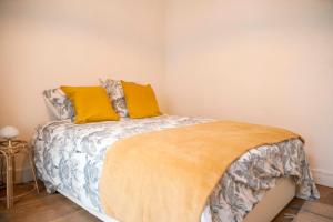 ein Schlafzimmer mit einem Bett mit zwei gelben Kissen in der Unterkunft Bright 36m2 near Vincennes in Vincennes