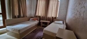 een kleine kamer met twee bedden en een raam bij Snow magic Grand Monastery in Pamporovo