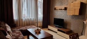 ein Wohnzimmer mit einem Sofa, einem TV und einem Tisch in der Unterkunft Snow magic Grand Monastery in Pamporowo