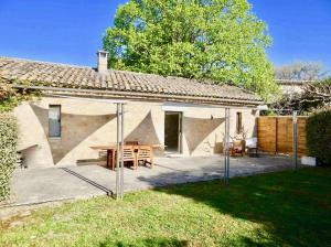 a house with a picnic table in front of it at Les Cerisiers maison bertuli climatisé, Piscine chauffée, lit King size, classé 5 étoiles in Oppède
