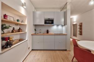 ボルツァーノにあるLauben Flat Bolzanoの白いキャビネットとテーブル付きのキッチン